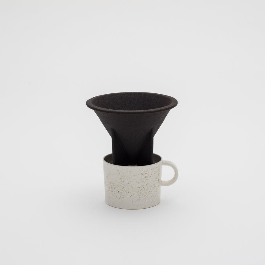 Porcelain filterless coffee dripper designed by Big Game for Arita 2016. Black, porous rock dripper with fins. Handmade in Arita, Japan. Contemporary ceramics.