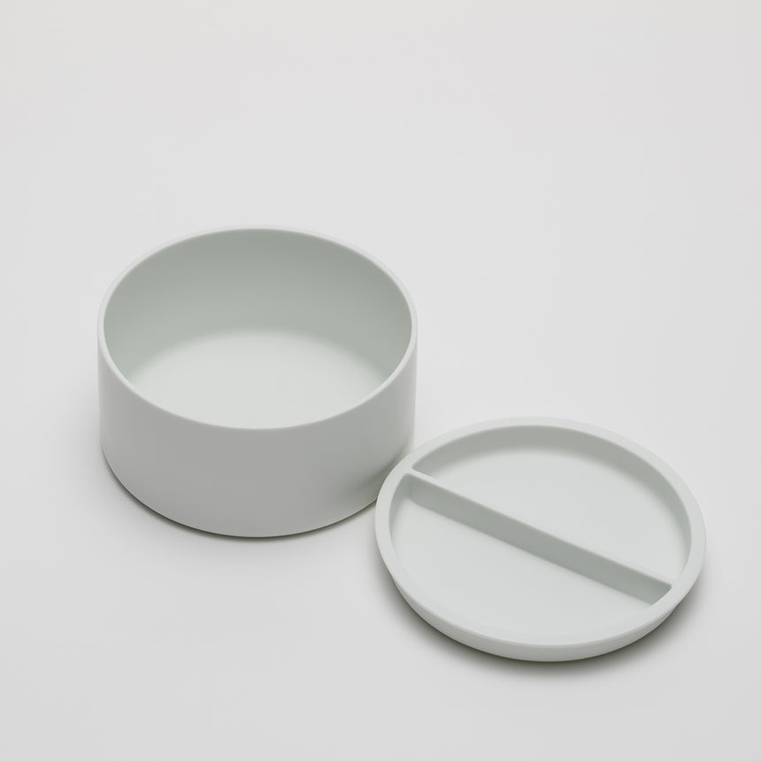 Wide, short porcelain container designed by Shigeki Fujishiro for Arita 2016. Handmade in Japan. Contemporary ceramic with fitted lid, unglazed exterior, matte finish. Top removed and set next to container.