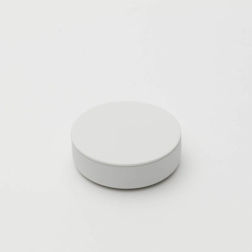 White porcelain jewelry holder designed by Saskia Diez for Arita 2016. Handmade in Japan. Glazed interior, matte exterior. Water drop detail in middle with thin walled lid fitted on top.