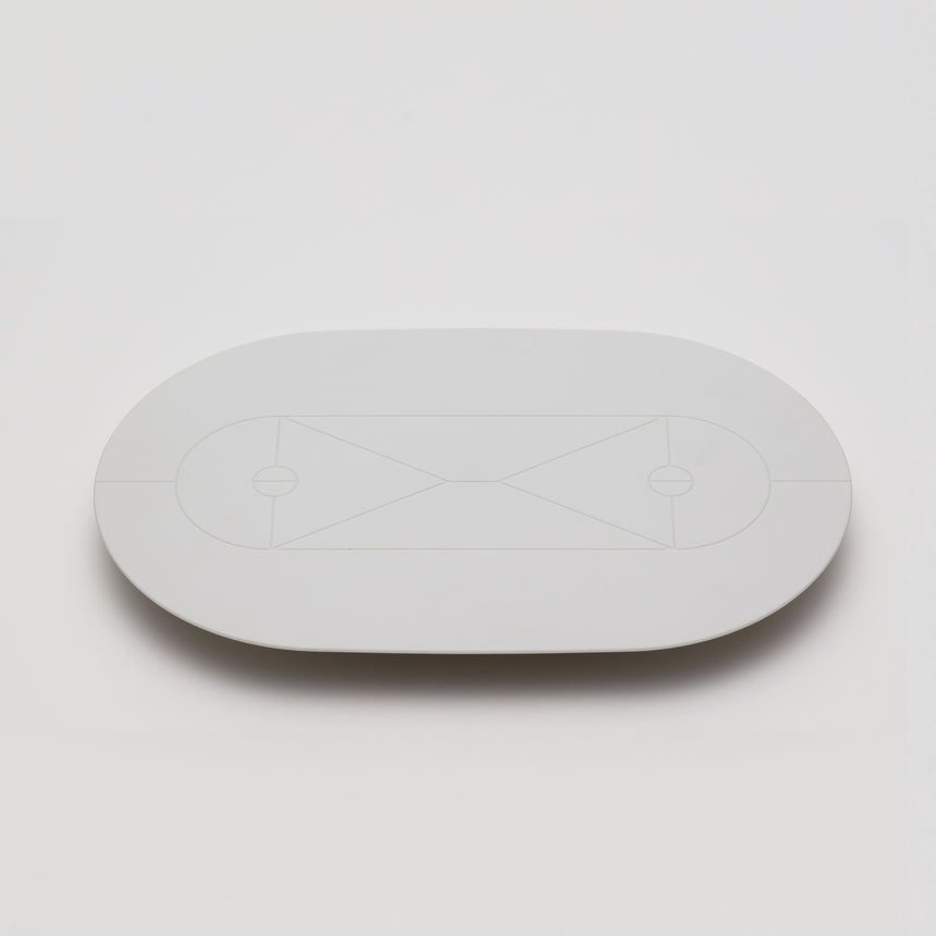 White matte serving tray designed by Christian Haas for Arita 2016. Handmade in Japan. Elongated circular serving tray, elevated by triangular feet with geometric court-style patter on surface.